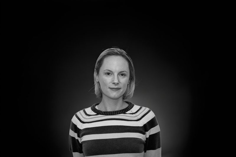 Black and white headshot of a woman in a striped jumper